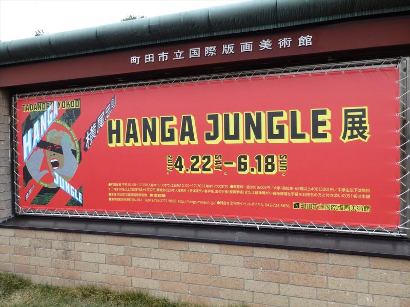町田市立国際版画美術館の案内板に赤い下地で『hangajungle展』と黒のゴシック体で書かれた案内ポスター