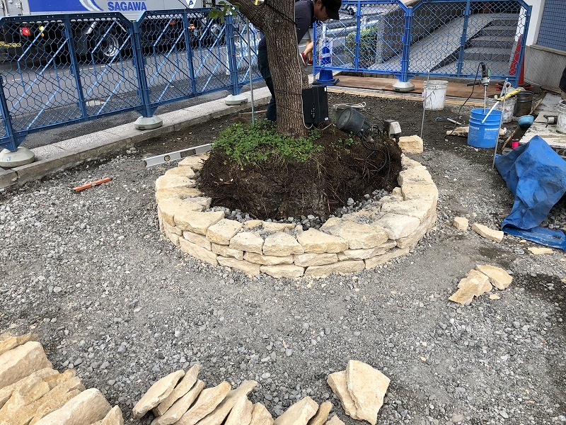 イギリスのコッツウォルズ地方のハニーストーンで三段目の石積みが終わった円形花壇