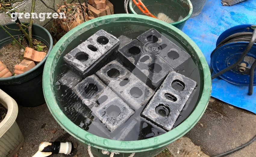 乾燥したレンガを水につけて水分を吸わせる工程