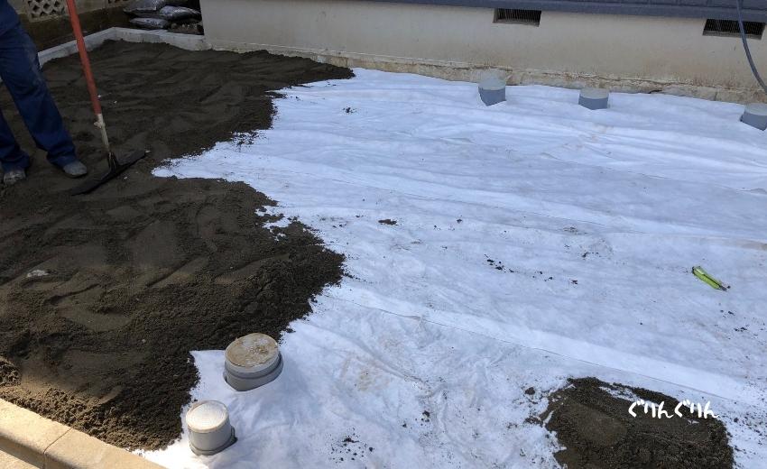 砂を敷き詰めるために不燃布を敷く緑化ブロックの施工