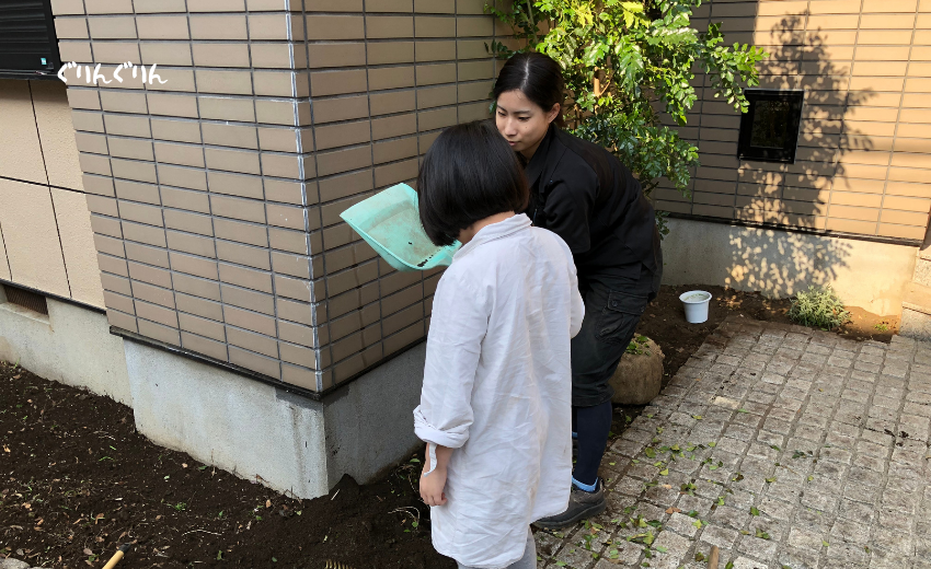 杉並区の個人邸で植物の植え方についてレクチャーを受ける子供