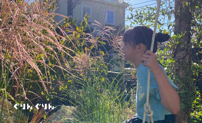 ぐりんぐりんの庭づくりのシンボル桜の木のブランコに乗る代表の横田の姪っ子
